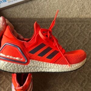 Vibrant Orange-Red Adidas Sneakers with Black Stripes and Cushioned Sole